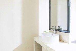 A bathroom with a white sink, a mirror, and a light-colored countertop. - Fuguilou Hotel (Gucheng)