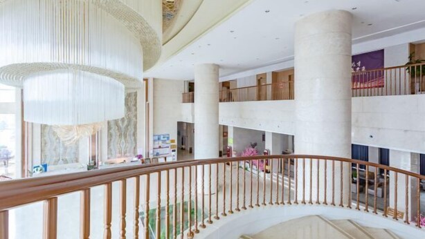 Un interior espacioso con una escalera curva, techos altos y un diseño moderno.