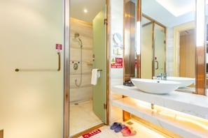 A modern bathroom with a large mirror, a white sink, and a shower area. - Dansha Hotel (Wuchuan)