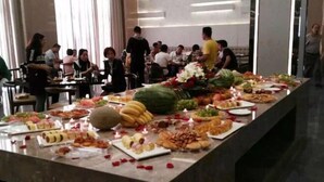 Montaje de bufé con diferentes opciones de comida y una mesa larga.
