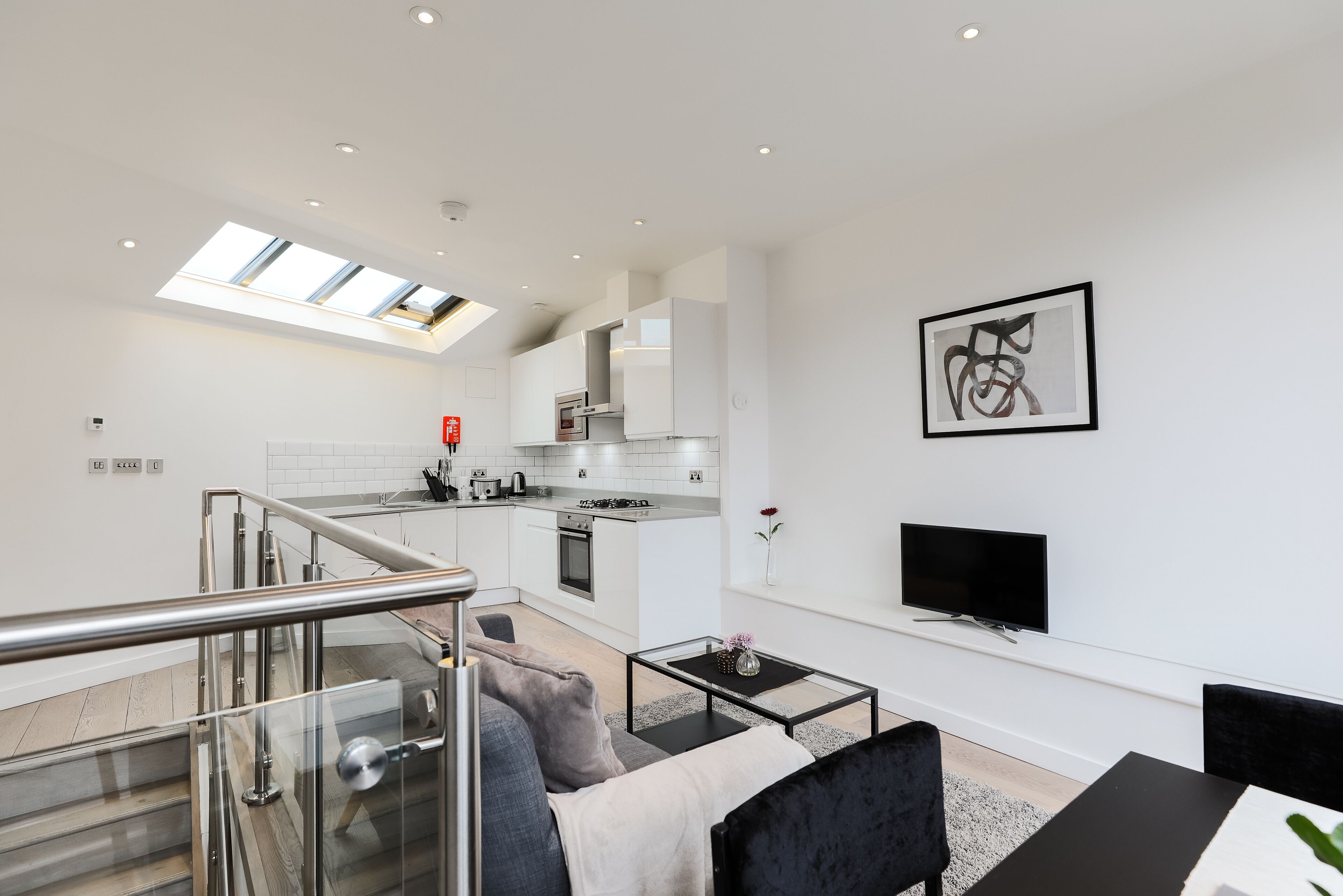 A modern apartment with a kitchen, dining area, and living room.
