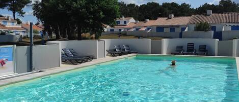 Una piscina al aire libre, una piscina climatizada