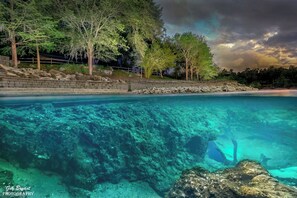 A clear view of a beach with a rocky shoreline and a stone wall. - Royal Springs Riverfront Retreat on 3 acres, kayak/canoe, boat ramp, huge decks! (obrien)