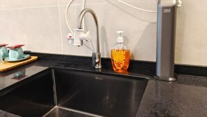 Eine Spüle mit Armatur, eine Seifenspender und ein 3M-Produkt auf der Arbeitsfläche.