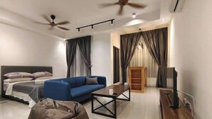 Ein modernes Wohnzimmer mit Sofa, Couchtisch, Sitzsack, TV-Schrank und Deckenventilator.