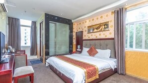 A hotel room with a bed, desk, chair, and a large window. - Mindu Hotel (Shenzhen)