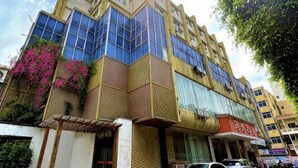 A multi-story building with large windows, a visible entrance, and a storefront with signage. - Mindu Hotel (Shenzhen)