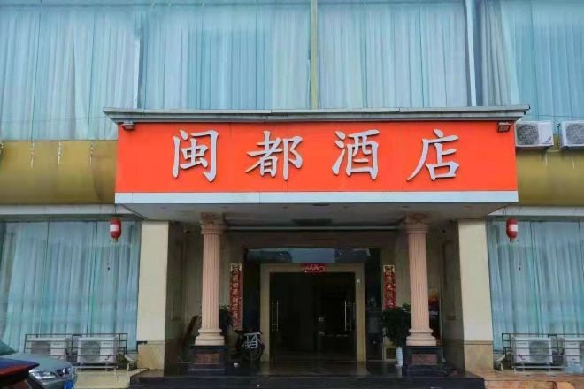 A hotel entrance with a prominent red sign displaying the name.
