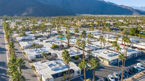 A large parking lot with numerous RVs and trailers, surrounded by palm trees and mountains in the background. - Boho chic condo at the mid-century Ocotillo Lodge (Palm Springs)