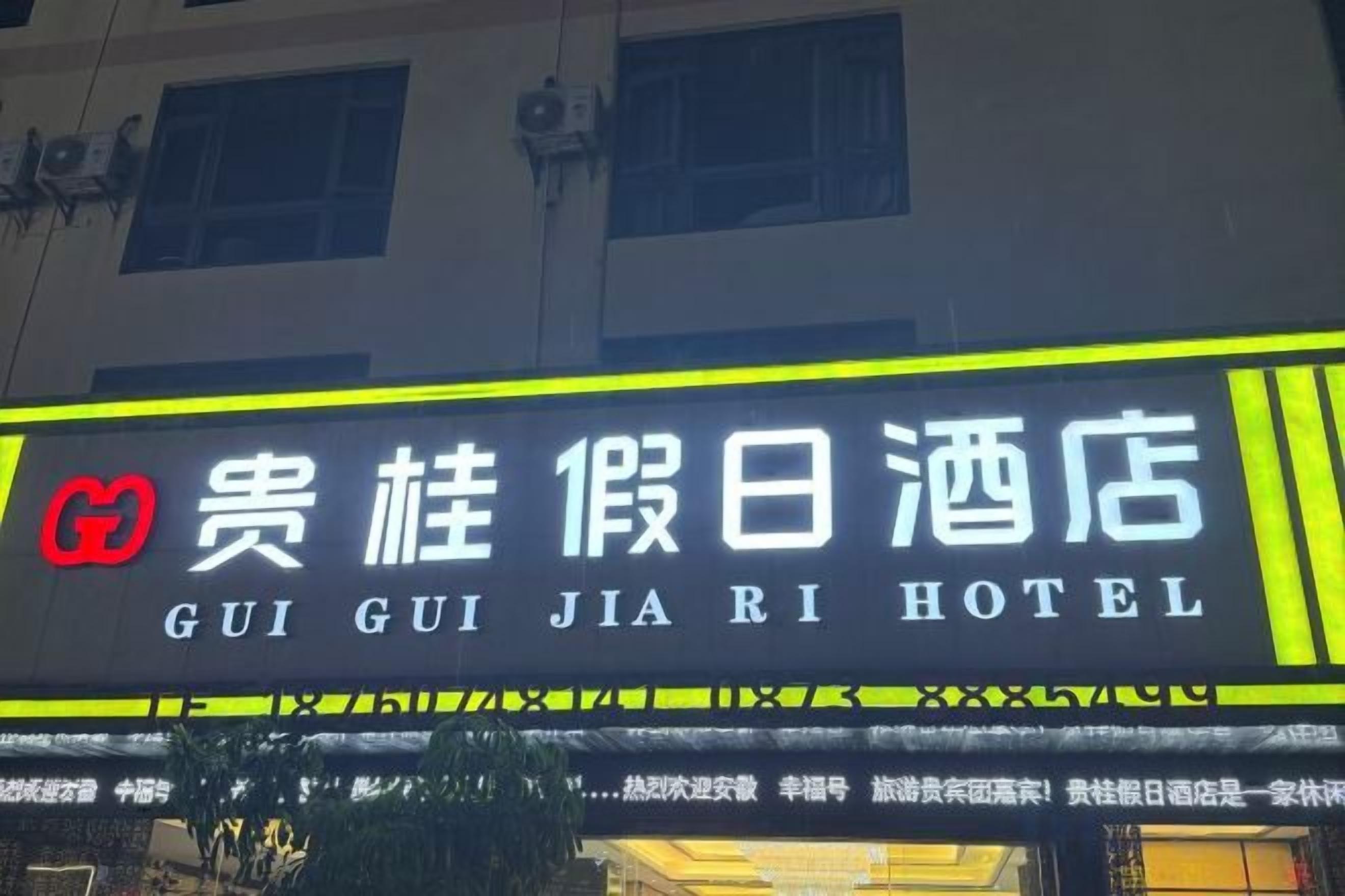 Un letrero de hotel con caracteres chinos y el nombre 'GUI GUI JIA RI HOTEL' en inglés.
