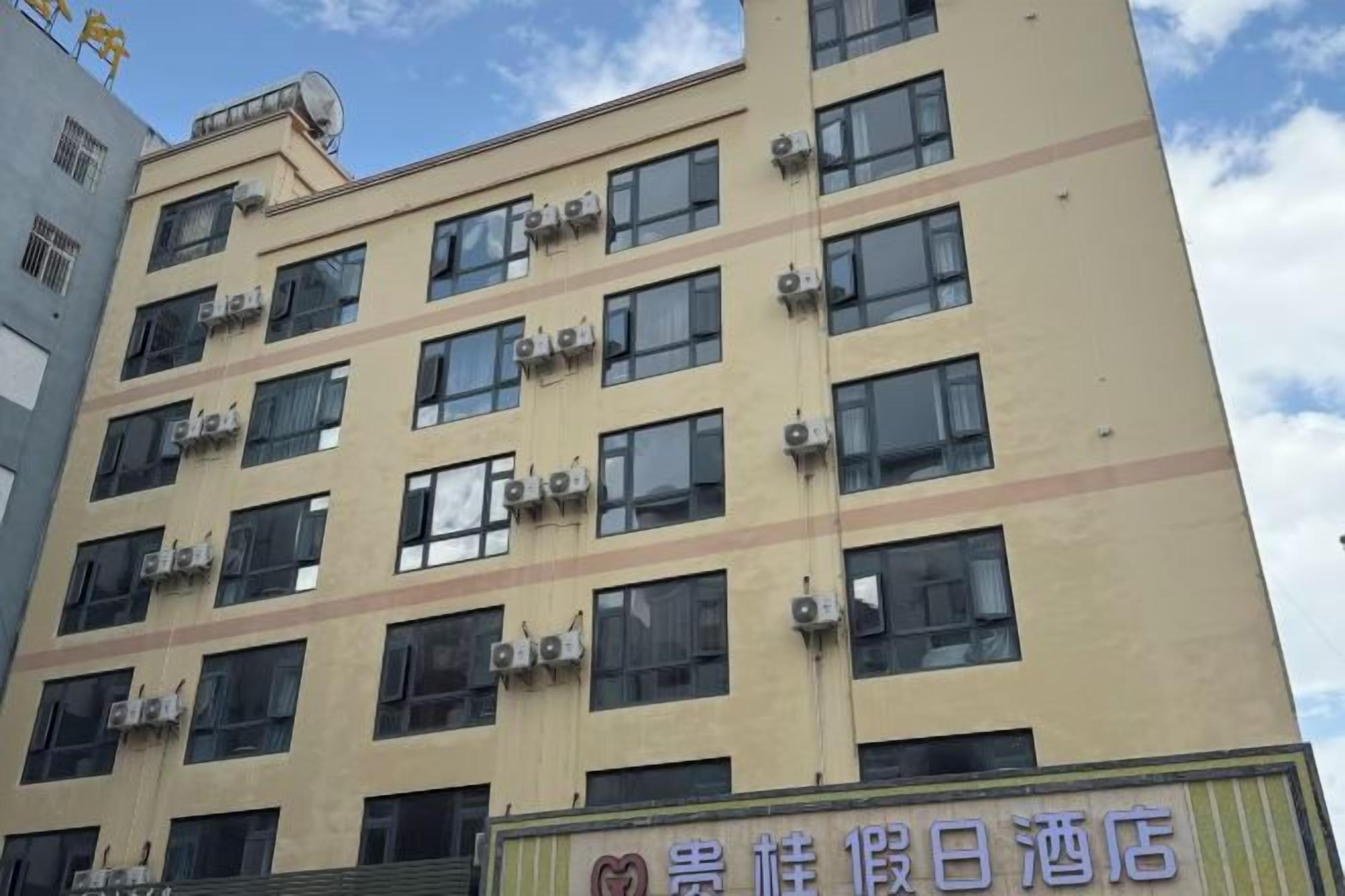 Een hotel met meerdere verdiepingen en airconditioning op de gevel.