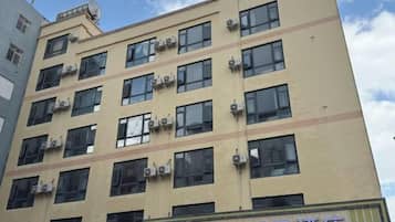 A multi-story hotel building with air conditioning units on the facade.