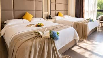 A hotel room with two beds, a large window, and a view of greenery outside.