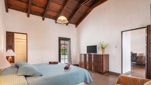 A bedroom with a bed, a sofa, a TV, and a cabinet. - Casita El Mirador  (Antigua Guatemala)