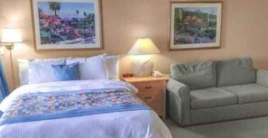Relax in this inviting room with a comfortable bed, sofa, and elegant artwork.