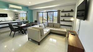 A modern living room with a sofa, dining table, and TV. - Marina del Rey (Mazatlán)