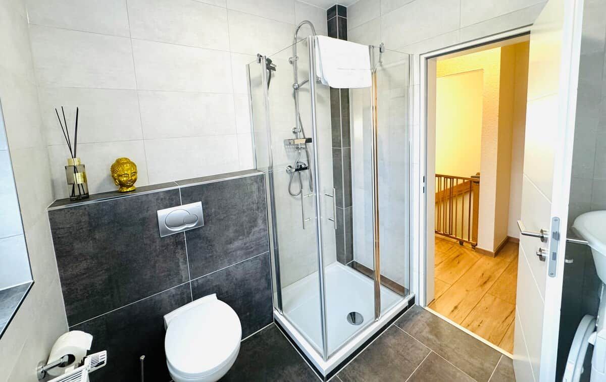 Une salle de bain moderne avec une douche à parois de verre, des toilettes et un bidet.