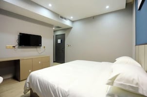 Una habitación de hotel moderna con cama, escritorio y televisión.
