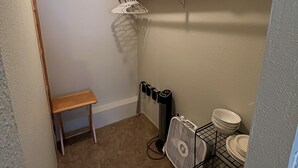 A compact bathroom with a bench, a towel rack, a radiator, and a shelf with towels. - Alaskan studio in the mountains (Anchorage)