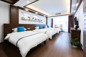A hotel room with three beds, a large window, a flat-screen TV, and a painting on the wall.