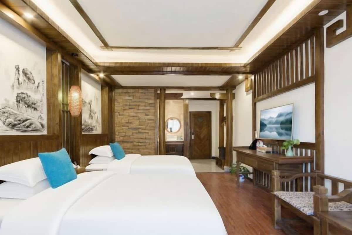 Une chambre d’hôtel avec un grand lit, une télévision et des œuvres d’art accrochées aux murs.