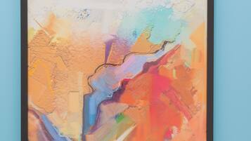 Een lijst met een abstract schilderij, met een mix van kleuren en texturen.