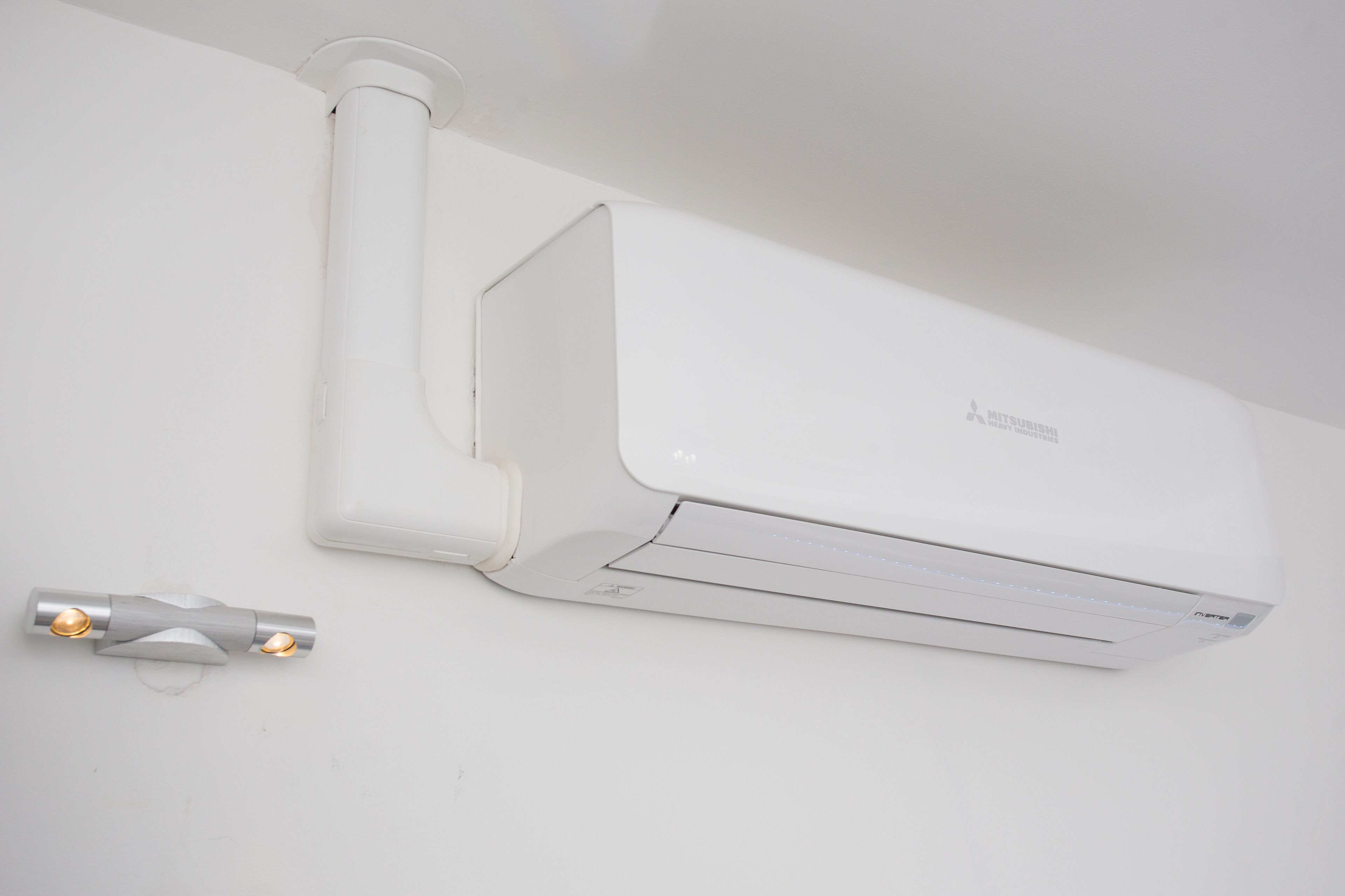 Een witte airconditioningunit aan een muur bevestigd.