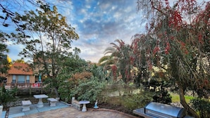 An outdoor patio with a grill, seating, and a small water feature.