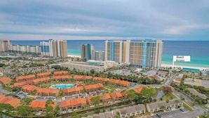 A resort with multiple buildings, a pool, and a beach access point.