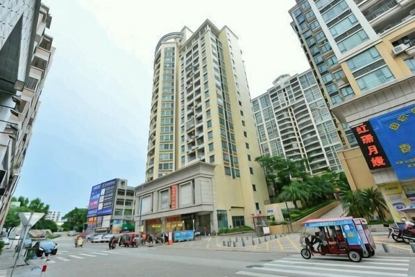 A multi-story building with a prominent entrance and a pedestrian crossing.