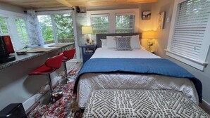 Ein Schlafzimmer mit einem Bett, einem Schreibtisch und zwei Stühlen.