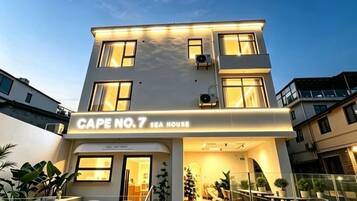 Un edificio moderno con un cartello che riporta la scritta 'Cape No.7 Sea House'.