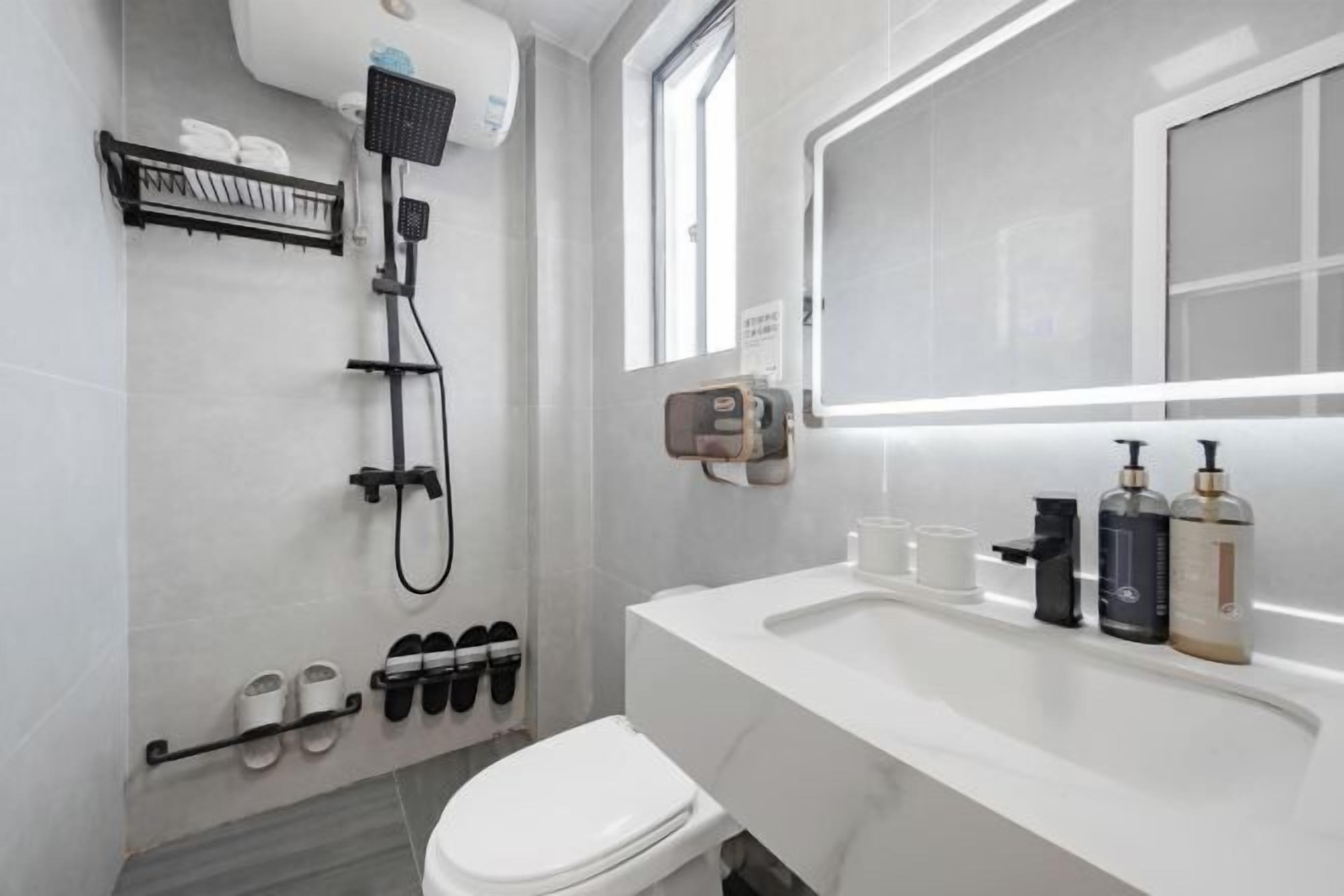 A modern bathroom with a shower, toilet, and sink.