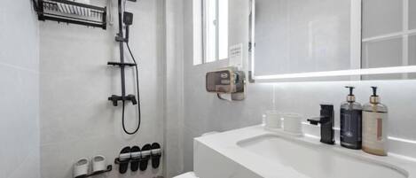 A modern bathroom with a shower, toilet, and sink.