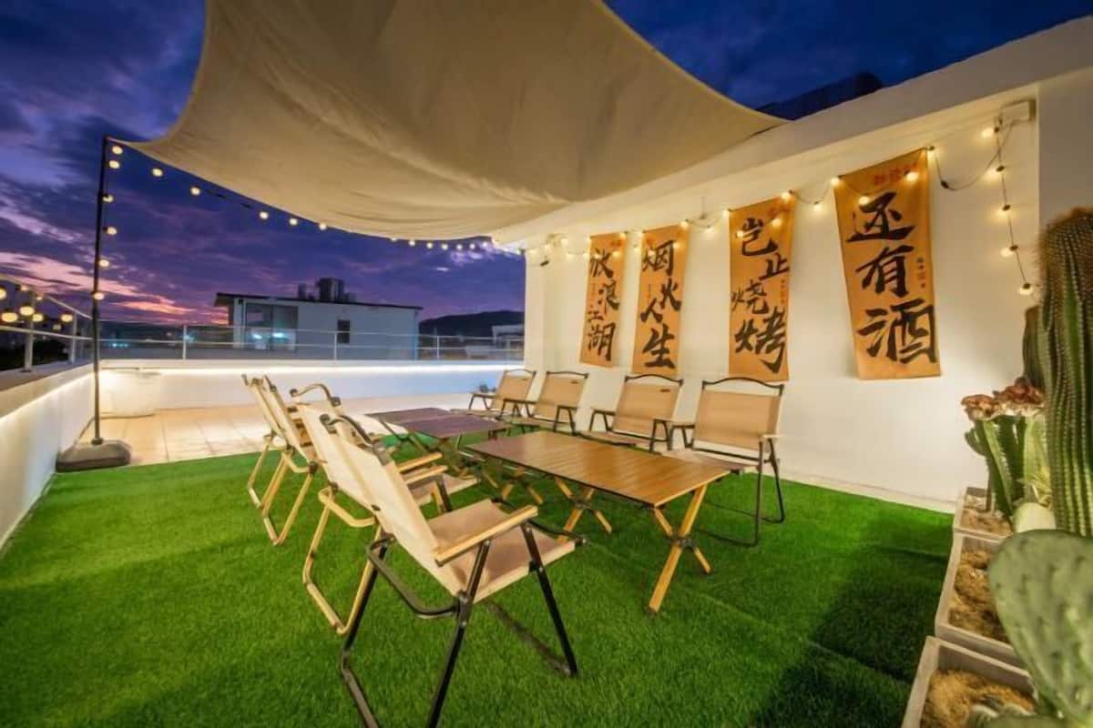 Terraza exterior con zona de comedor, césped artificial y cactus.