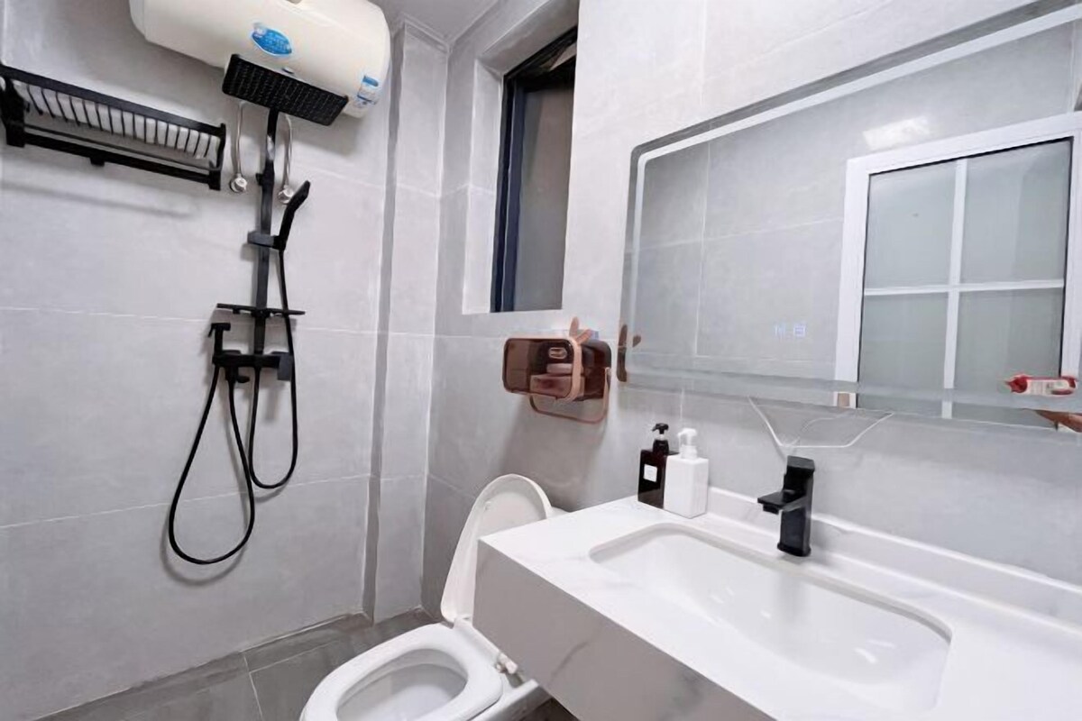 A modern bathroom with a toilet, sink, and shower.