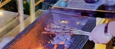 A grill with food being cooked over an open flame.