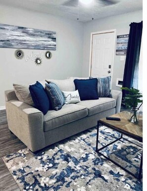 Relax in this inviting living space with a sofa, patterned rug, and small table.