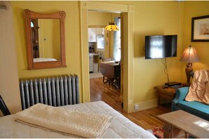 Relax in this cozy space with a comfortable bed, TV, and natural light from the window.