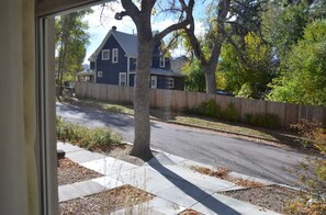 Situated on a corner lot, this two-story house features a charming exterior with a tree in the foreground.
