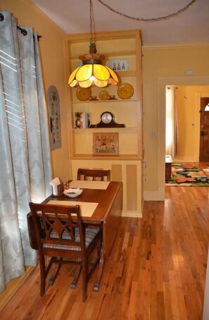 Enjoy meals in this dining area with a wooden table and chairs, a pendant light, and a convenient wall-mounted shelf.