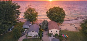 Luchtbeeld van een kustgebied met woningen, bomen en een strand.