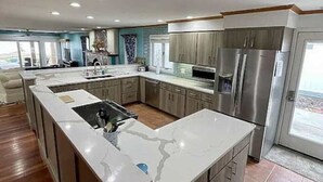 A spacious kitchen with a large island, stainless steel appliances, and a view to the outside. - Libby`s Cove - Swim spa open all year! kayaks&more (Port Sanilac)