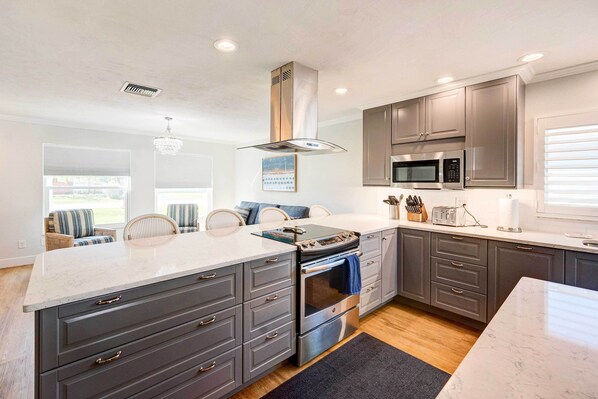 Enjoy cooking in this well-lit kitchen with a large island and stainless steel appliances.