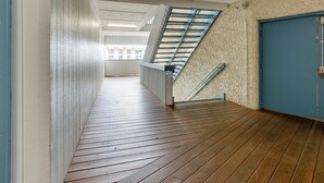 A corridor with wooden flooring, a staircase, and a blue door. - On-Site Beach Access: Apt in Hilton Head Island! (Hilton Head Island)