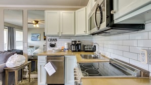 A compact kitchen with white cabinets, a microwave, a coffee maker, and a dishwasher. - On-Site Beach Access: Apt in Hilton Head Island! (Hilton Head Island)