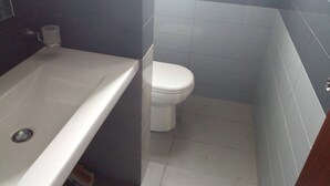 A bathroom with a bathtub, toilet, and tiled walls. - Luxury Apartment in Colombo 7 (Colombo)