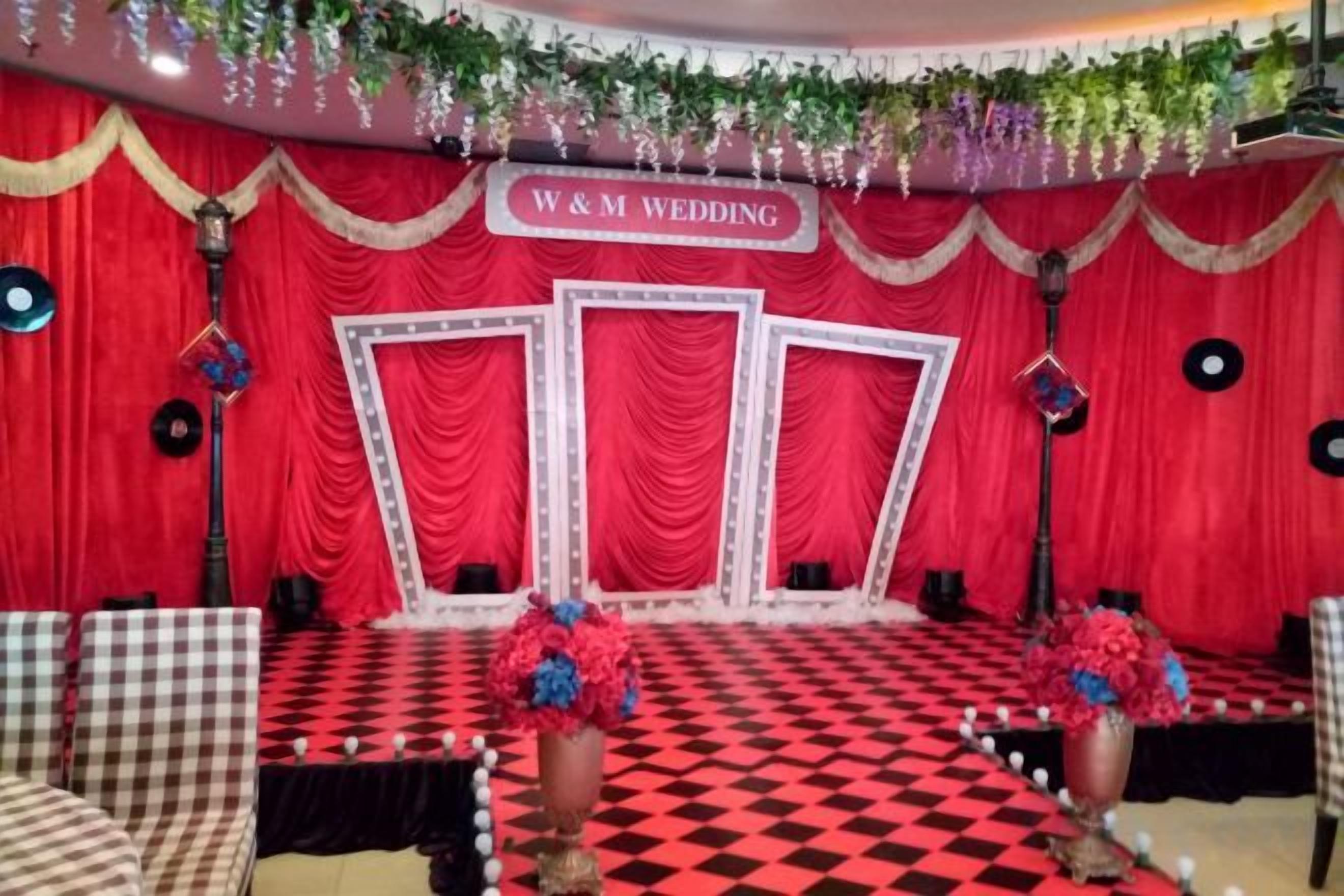 Un escenario con un fondo rojo y un cartel que dice 'W & M Wedding'.