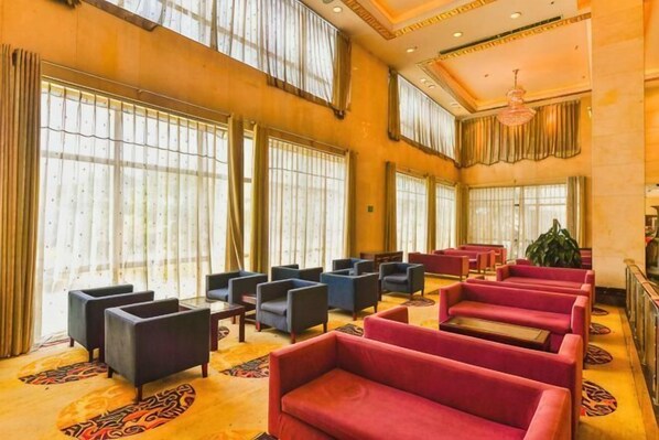 A hotel lobby with rows of seating, large windows, and a chandelier. - Yu Jing Lou Hotel (Ci County)