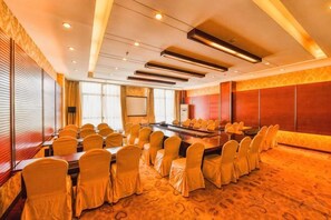 A conference room with a long table, multiple chairs, and a projector screen. - Yu Jing Lou Hotel (Ci County)